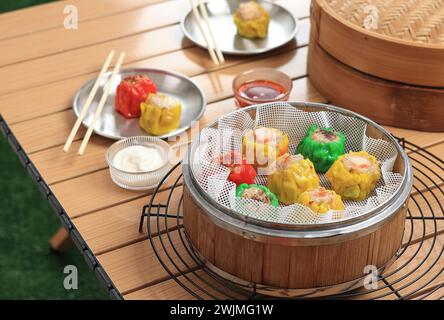 Buntes Dimsum Dumpling Chinese Siew May Sioma auf Bambusdampfer Stockfoto