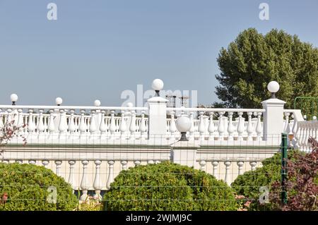 Fragment der Terrasse mit Säulen, Lampen und Geländern. Geländer aus weißem Stein oder Marmor mit Säulen, Balustern und Handläufen Stockfoto