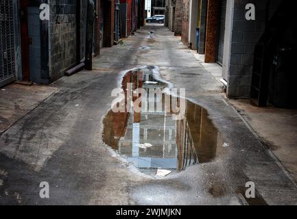 Reflexion in einem Pool mit stehendem Wasser in einer Gasse in der Innenstadt Stockfoto