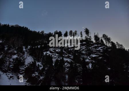 Srinagar, Indien. Februar 2024. Der wachsende Halbmond erhebt sich über dem schneebedeckten Berg am Stadtrand von Srinagar, der Sommerhauptstadt von Jammu und Kaschmir. (Credit Image: © Saqib Majeed/SOPA Images via ZUMA Press Wire) NUR REDAKTIONELLE VERWENDUNG! Nicht für kommerzielle ZWECKE! Stockfoto