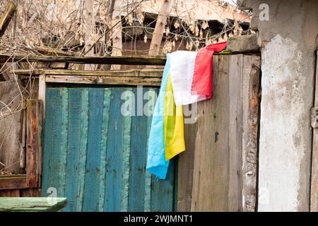 Die Flagge der Ukraine und Polens hängt an der Mauer eines zerstörten alten Hauses in der Ukraine im Dnieper Stockfoto