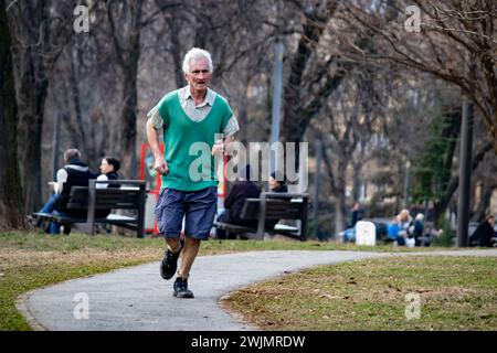 Älterer Mann, der morgens im öffentlichen Stadtpark joggen, draußen laufen, gesund leben und fit bleiben Stockfoto