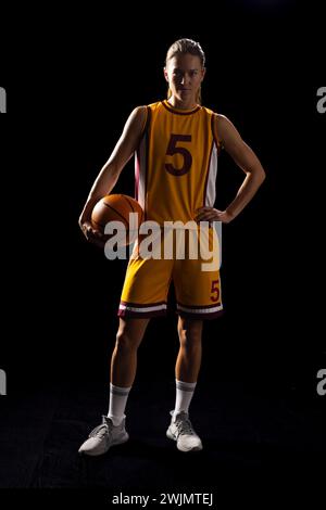 Sportliche Basketballspielerin strahlt Können und Entschlossenheit in Uniform aus. Stockfoto