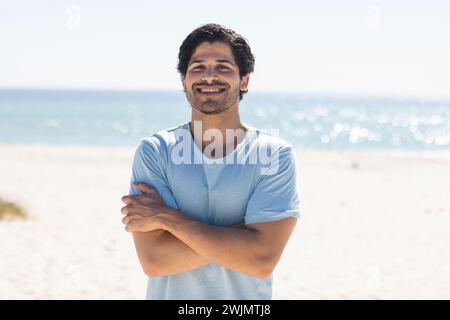 Ein junger birassischer Mann lächelt am Strand Stockfoto