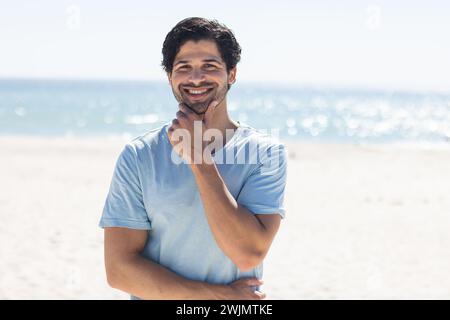 Ein junger, birassischer Mann lächelt am Strand Stockfoto