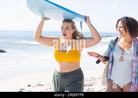 Junge kaukasische Frau und birassische Frau genießen einen sonnigen Strandtag Stockfoto