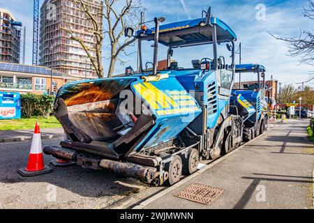 Ein Asphaltfertiger, der am Straßenrand abgestellt wird, ist ein Industriefahrzeug, das für die Verlegung neuer Straßen oder die Sanierung bestehender Straßen verwendet wird. Stockfoto