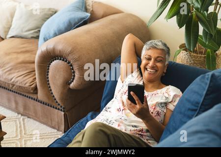 Eine reife, birassische Frau genießt einen entspannten Moment zu Hause, mit Kopierraum Stockfoto