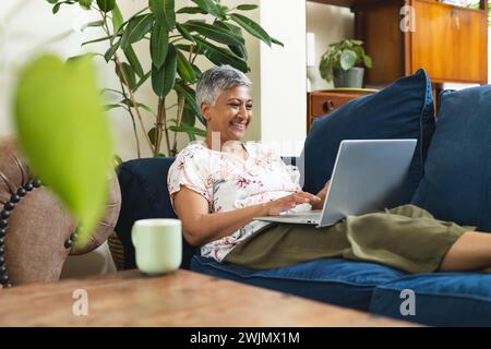 Eine reife Frau arbeitet zu Hause an ihrem Laptop Stockfoto