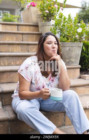 Die junge Frau in Übergröße genießt einen entspannten Morgen im Freien Stockfoto