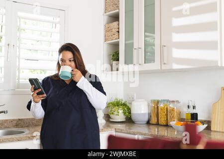 Junge Plus Size biracial weibliche Gesundheitsberaterin genießt einen Morgenkaffee zu Hause Stockfoto