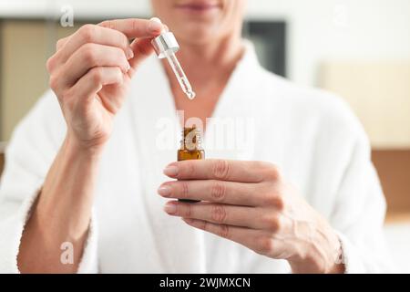 Kaukasische Frau mit Gesichtsserum zu Hause Stockfoto