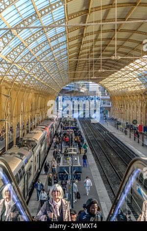 Passagiere, die einen Zug in Nizza-Ville verlassen, dem Hauptbahnhof der TGV-Linie. Eine Frau mit grauen Haaren ist der erste Passagier, der die Rolltreppen hochfährt. Stockfoto