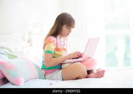 Teenager mit Computer. Ein Mädchen, das mit Freunden auf der Website chattet. Schüler macht Hausaufgaben auf einem Laptop. Remote Study (Fernstudie). Online-Kurs. Stockfoto