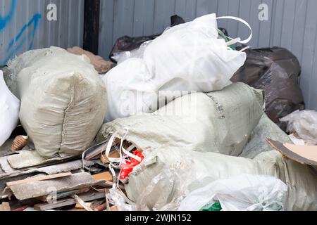 Ein Haufen Bauschutt in weißen Säcken in der Nähe eines neuen Gebäudes, Müll in Säcken Stockfoto