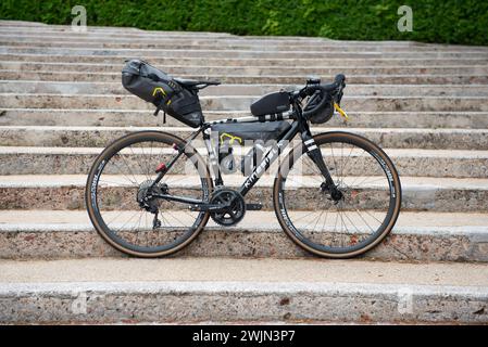 Ein Fahrrad-Tourenrad mit Taschen an Rahmen, Sattel und Lenker neigt sich gegen die aufsteigenden Stufen Stockfoto