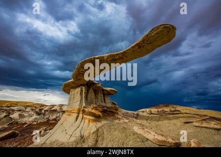 Der King of Wings, ein sehr zerbrechlicher Sandstein-Hoodoo in den Badlands des San Juan Basin in New Mexico, mit Sturmwolken dahinter. Stockfoto