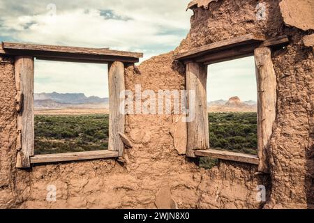 Die Fenster einer alten Ruine in Hot Springs umrahmen die Wüstenlandschaft im Big Bend National Park in Texas. Stockfoto