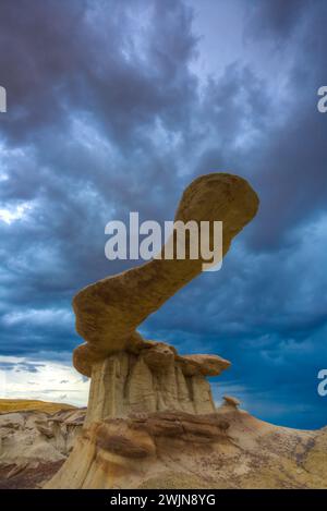 Der King of Wings, ein sehr zerbrechlicher Sandstein-Hoodoo in den Badlands des San Juan Basin in New Mexico, mit Sturmwolken dahinter. Stockfoto