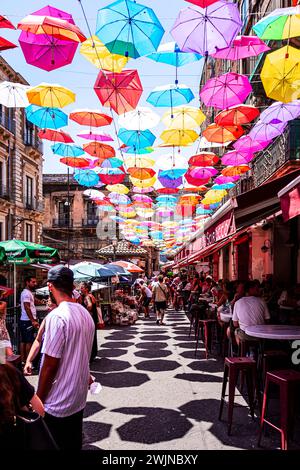 Der einzigartige Piscaria-Markt in Catania, wo farbige Regenschirme installiert wurden, um Touristen vor den Sonnenstrahlen zu schützen Stockfoto