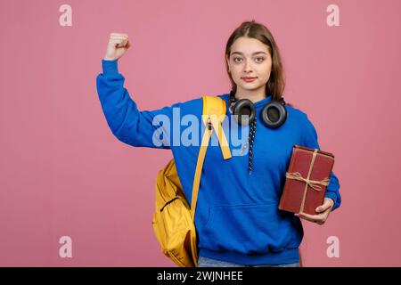 Junger Schüler, der steht, die Hand hebt, stark zeigt. Stockfoto