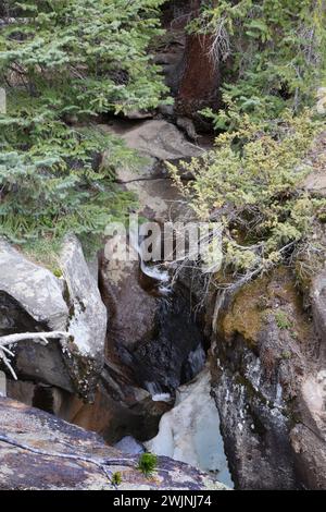 Der Grottos Trail im White River National Forest in Colorado, USA, ist ein kleiner, rauschender Wasserfall und Schneesack in zerklüfteten Felsen Stockfoto