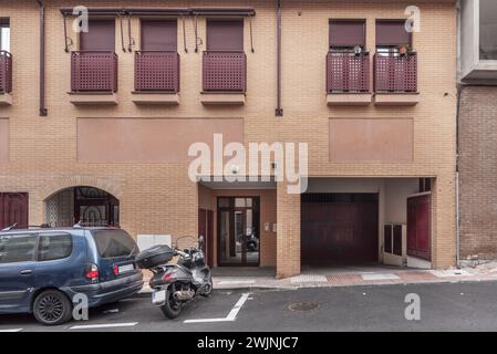 Hauptfassade eines zweistöckigen städtischen Wohnhauses mit Portal und Zugangstür zur Garage Stockfoto