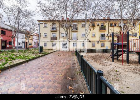 Fassaden flacher Stadthäuser auf einem großen Platz mit Kinderspielplätzen mit Sandböden Stockfoto