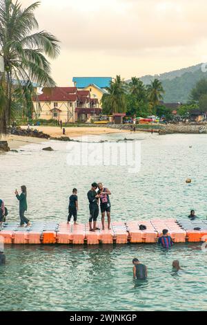 Eine Gruppe von Menschen hat Spaß auf der schwimmenden Brücke auf der Insel Perhentian Stockfoto