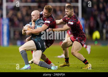 Huddersfield Giants’ Adam Swift (links) wird von Matt Davis (rechts) und Matt Moylan (rechts) während des Spiels der Betfred Super League im Leigh Sports Village angegriffen. Bilddatum: Freitag, 16. Februar 2024. Stockfoto