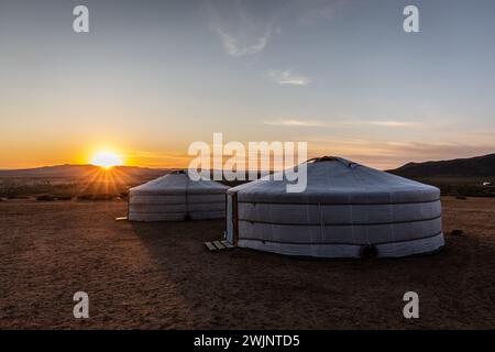 Die Morgensonne taucht zwei Jurten in der zentralen Mongolei in ein Morgenglühen. Stockfoto