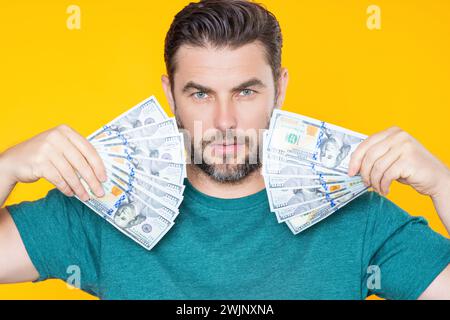 Erfolgreicher Geschäftsmann, der Geld zählt. Ein gutaussehender Mann mittleren Alters, der einen Haufen 100-Dollar-Banknoten in der Hand hat. Ein Typ mit Bargeld. Gewinn und Finanzen Stockfoto