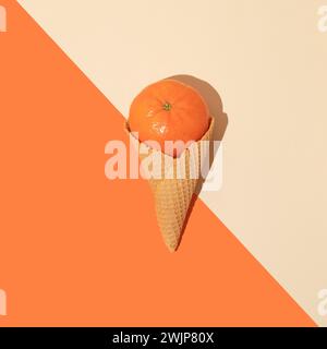 Mandarine in Eiskegel auf orange-beigem Hintergrund. Minimales Sommer-Food-Konzept. Flache Lagen. Stockfoto