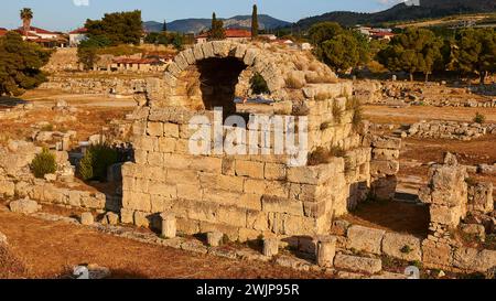 Ruinen einer antiken Struktur mit Vegetation im Hintergrund, archäologische Stätte, Archea Korinthos, Korinth, Peloponnes, Griechenland Stockfoto