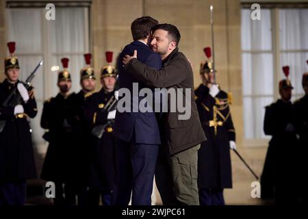 Paris, Frankreich. Februar 2024. Der französische Präsident Emmanuel Macron, links, umarmt den ukrainischen Präsidenten Wolodymyr Zelenskyj, rechts, bei der Ankunft im Elysee-Palast am 16. Februar 2024 in Paris, Frankreich. Quelle: Pool Photo/Ukrainische Präsidentenpresse/Alamy Live News Stockfoto