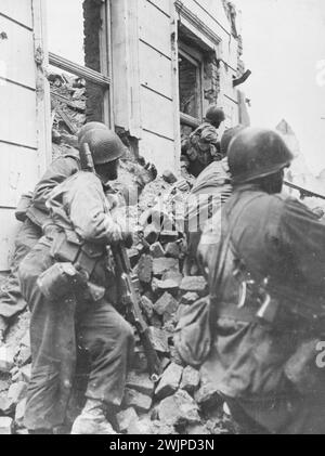 US-Infanteristen Schlacht in Trümmern -- verstreute Kölner Infanteristen der 104. Division, First U.S. Army, erobern während der schweren Straßenkämpfe, die der Eroberung von Köln, Deutschland, am 6. März 1945, vorausgingen, hinter einem Schutthaufen Zuflucht. Köln, drittgrößte Stadt Deutschlands und Hauptstadt des Rheinlandes, war mit Trümmern gefüllt, als amerikanische Truppen durch die Straßen stürmten. April 1945. (Foto: U.S. Signal Corps Photo). Stockfoto