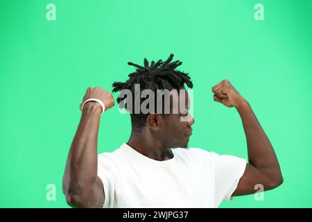 Mann, Nahaufnahme, auf grünem Hintergrund, zeigt Stärke. Stockfoto