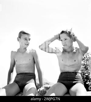 Zwei junge Teenager in Badeanzügen, die sich nach dem Schwimmen entspannen, Rupert, Idaho, USA, Russell Lee, U.S. Farm Security Administration, Juli 1942 Stockfoto