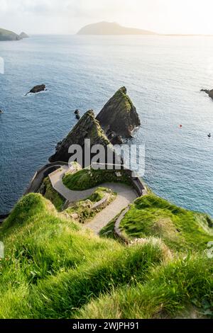 Dunquin oder Dun Chaoin Pier, Irlands Sheep Highway. Schmaler Pfad, der sich hinunter zum Pier, zur Küste des Ozeans und zu den Klippen schlängelt. Beliebter, ikonischer Ort auf Slea Stockfoto