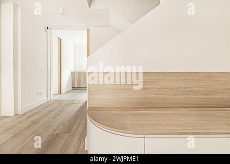 Flur eines Einfamilienhauses mit einem Holzsitz mit großen Schubladen darunter neben einigen gemauerten Treppen Stockfoto