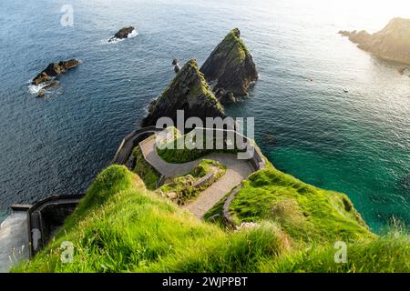 Dunquin oder Dun Chaoin Pier, Irlands Sheep Highway. Schmaler Pfad, der sich hinunter zum Pier, zur Küste des Ozeans und zu den Klippen schlängelt. Beliebter, ikonischer Ort auf Slea Stockfoto