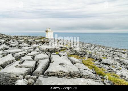 Black Head Lighthouse, gelegen in der rauen felsigen Landschaft von Burren, inmitten einer bizarren Landschaft mit steilen Kalksteinbergen und felsiger Küste, Cou Stockfoto