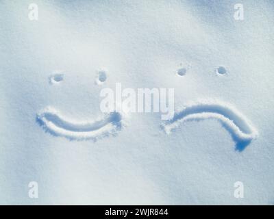 Emoji, Gesicht und Zeichnen im Schnee oder draußen auf dem Boden im Winter für Kommunikation oder Feedback. Schreiben, Zeichen und lächeln im Eis auf dem Feld in der Natur mit Stockfoto