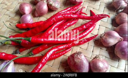 Foto von Gewürzen in Form von Schalotten, Knoblauch, Chilis und Eiern, die in einem gewebten Bambus angeordnet sind Stockfoto