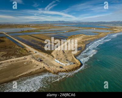 Blick aus der Vogelperspektive auf den Strand von Marquesa und das Restaurant Vascos, mit einem Felsdamm gegen die Regression des Ebro-Deltas (Tarragona, Katalonien, Spanien) Stockfoto