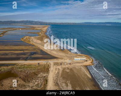 Blick aus der Vogelperspektive auf den Strand von Marquesa und das Restaurant Vascos, mit einem Felsdamm gegen die Regression des Ebro-Deltas (Tarragona, Katalonien, Spanien) Stockfoto