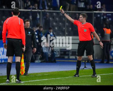 Berlin, Deutschland. Februar 2024. Fußball: Bundesliga 2, Hertha BSC 1. FC Magdeburg, 22. Spieltag, Olympiastadion, Schiedsrichter Florian Exner (r) zeigt Magdeburgs Cheftrainer Christian Titz eine gelbe Karte. Hinweis: Soeren Stache/dpa – WICHTIGER HINWEIS: gemäß den Vorschriften der DFL Deutscher Fußball-Liga und des DFB Deutscher Fußball-Bundes ist es verboten, im Stadion und/oder des Spiels aufgenommene Fotografien in Form von sequenziellen Bildern und/oder videoähnlichen Fotoserien zu verwenden oder zu nutzen./dpa/Alamy Live News Stockfoto