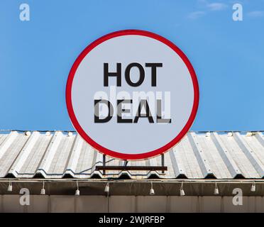 Auf dem Dach befindet sich eine kreisförmige Werbetafel mit einem Hot Deal. Stockfoto