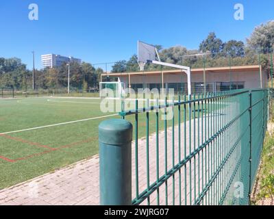 Metallzäune auf einem Sportbasketball-, Fußball-, Volleyballplatz mit Kunstrasen Stockfoto