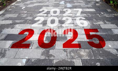 Neujahr 2025 oder einfaches Konzept. Der Text 2025 bis 2027 steht auf der Straße in der Mitte der Backsteinstraße. Neujahrskonzept 2025, begi Stockfoto